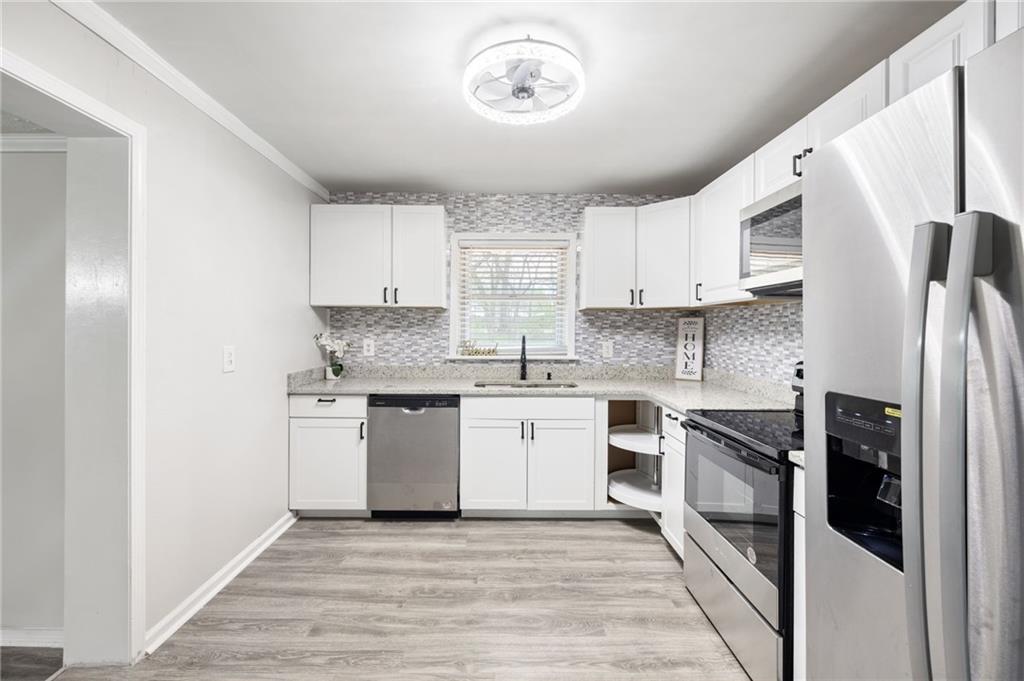 4611 Old Westside Road Austell, GA 30106 - Photo 13 of 37 a kitchen with stainless steel appliances granite countertop a stove a sink and a refrigerator
