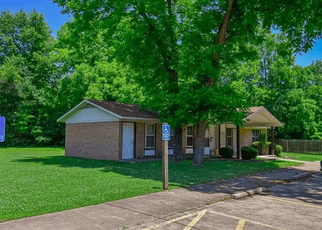 a front view of a house with a yard and trees