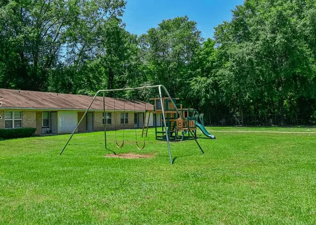 a view of a house with a backyard and a tree