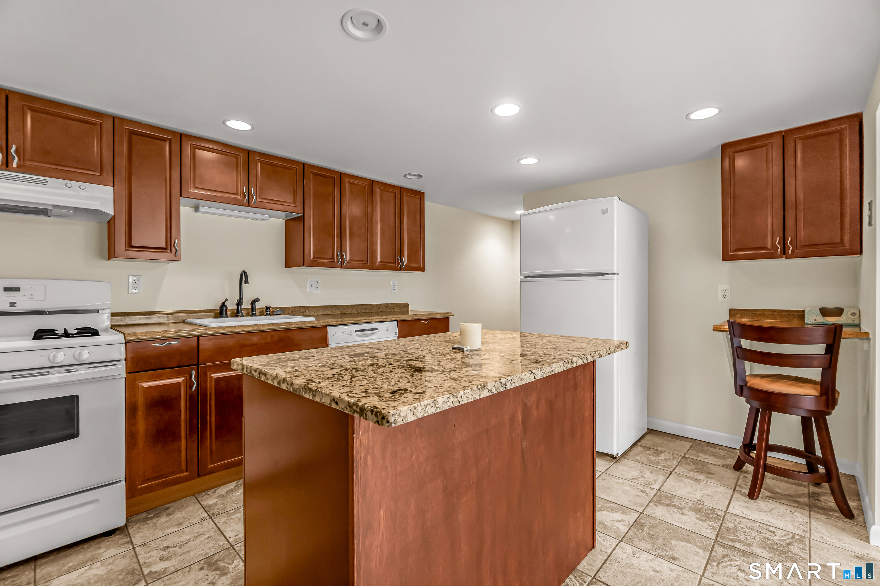 15 Bruns Road Ansonia, CT 06401 - Photo 20 of 39 a kitchen with stainless steel appliances granite countertop a stove a sink dishwasher and a refrigerator with wooden cabinets