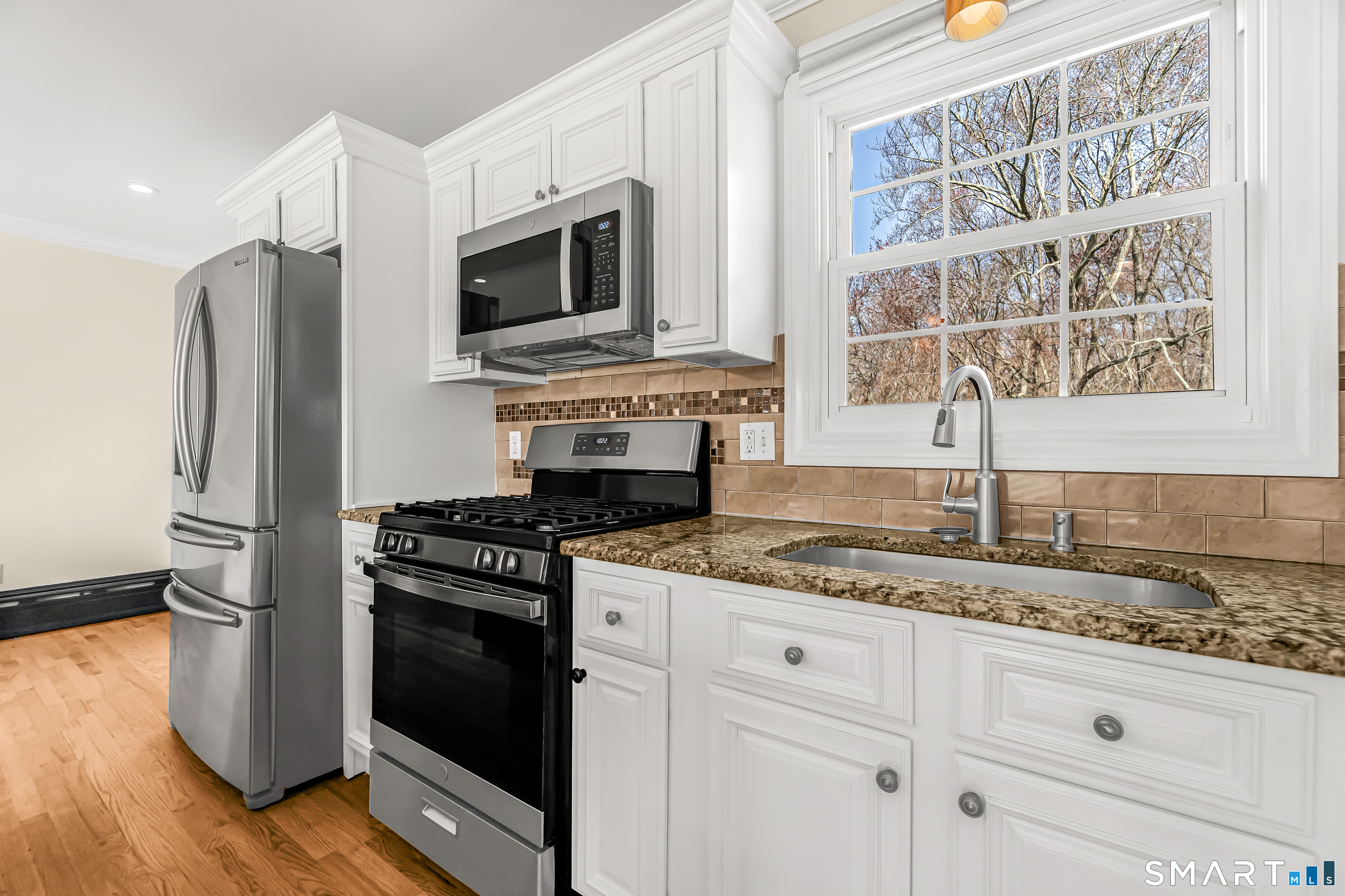 15 Bruns Road Ansonia, CT 06401 - Photo 7 of 39 a kitchen with granite countertop cabinets stainless steel appliances and a wooden floor