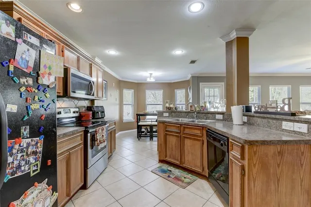 a kitchen with stainless steel appliances granite countertop a stove top oven a sink dishwasher and cabinets with wooden floor