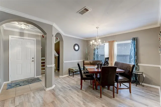 a view of a dining room with furniture and chandelier
