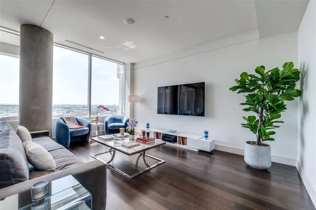 a living room with furniture potted plant with a large window