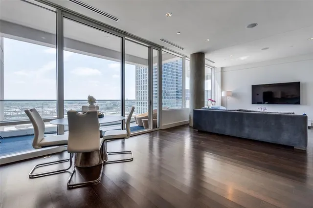 a living room with hard wood floor and a floor to ceiling window