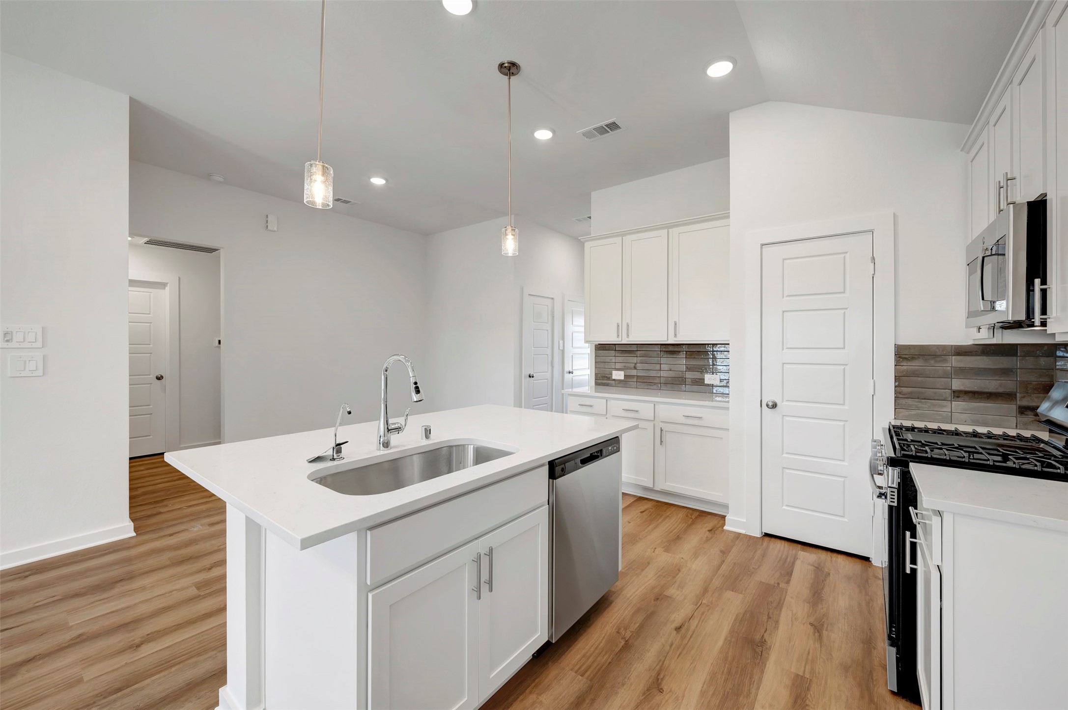 716 Hackberry Branch Magnolia, TX 77354 - Photo 21 of 32 a kitchen with a sink stove cabinets and wooden floor
