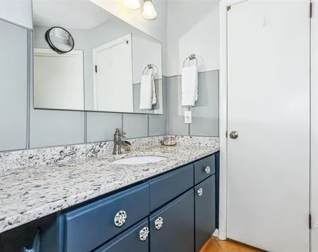 a bathroom with a granite countertop sink and a mirror