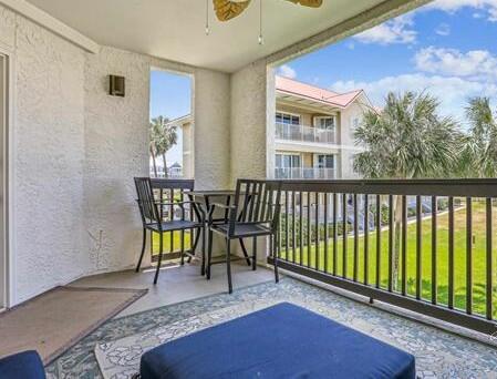 7453 Sunset Harbor Drive, Unit 2203 Navarre, FL 32566 - Photo 18 of 21 a view of a patio with table and chairs and wooden floor