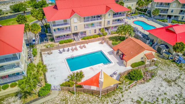 an aerial view of a multi story residential apartment building with a yard and outdoor seating