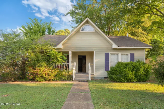 a front view of a house with yard and green space