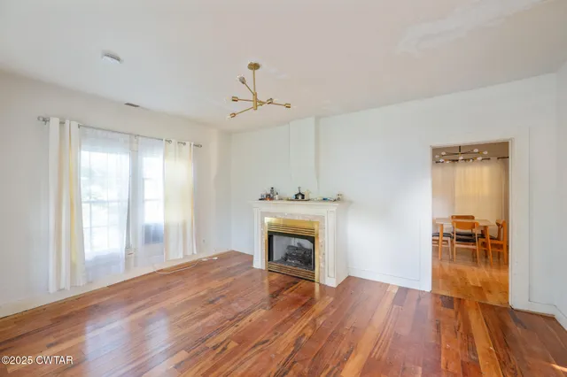 a view of empty room with wooden floor and fireplace