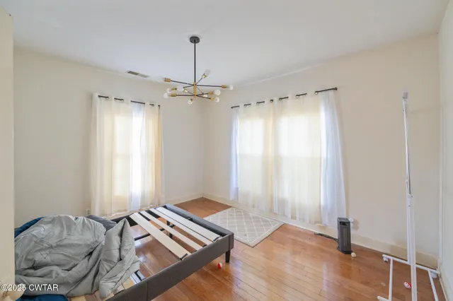 a living room with hard wood flooring and a window