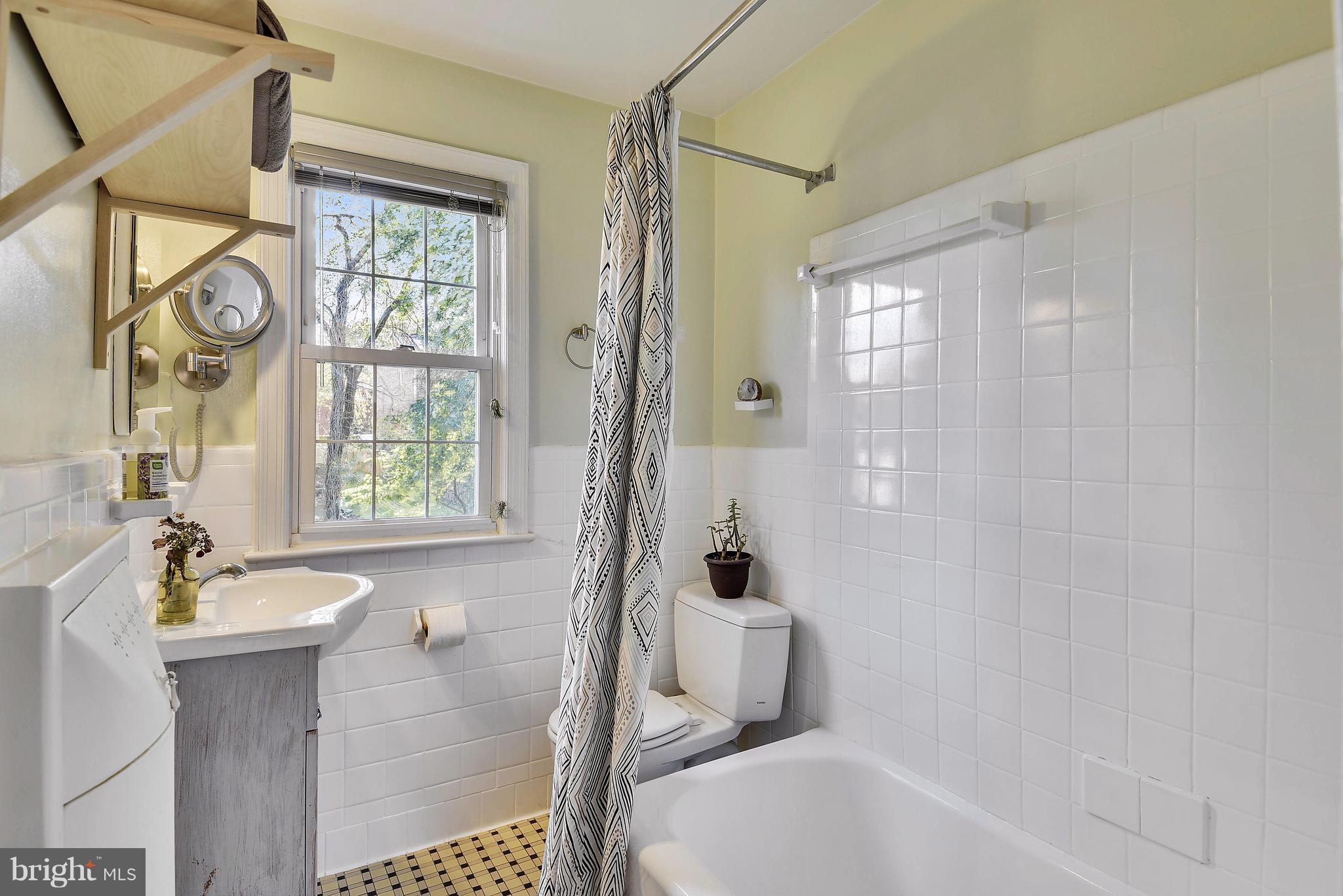 624 Wayne Avenue Silver Spring, MD 20910 - Photo 15 of 28 a bathroom with a bathtub a sink a window and a shower