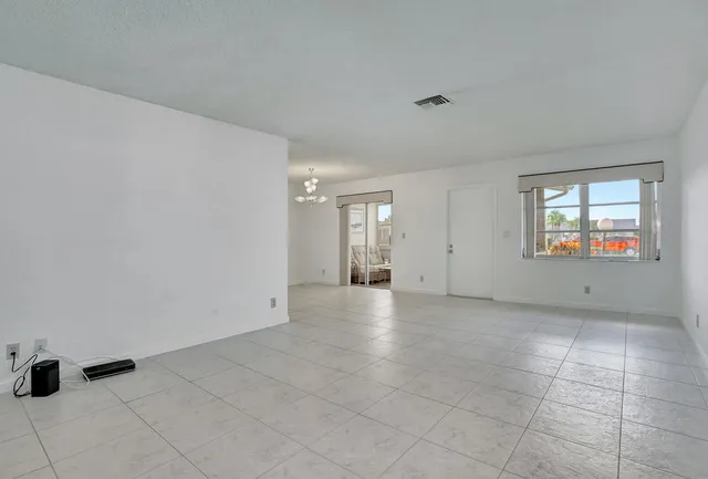 an empty room with windows and fireplace