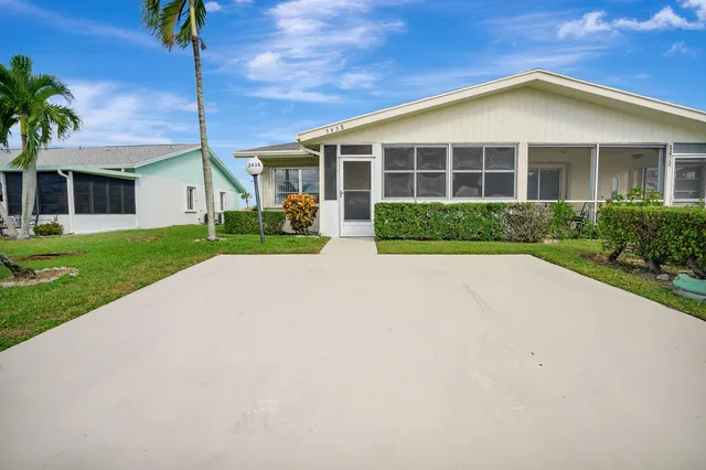 a front view of a house with a yard and potted plants