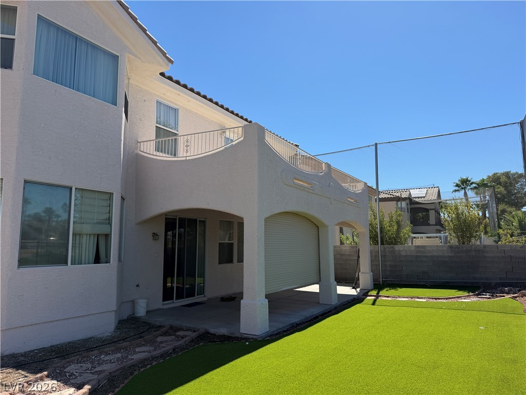 141 Rancho Maria Street Las Vegas, NV 89148 - Photo 21 of 30 An arched covered patio opens to a manicured lawn under clear desert skies.