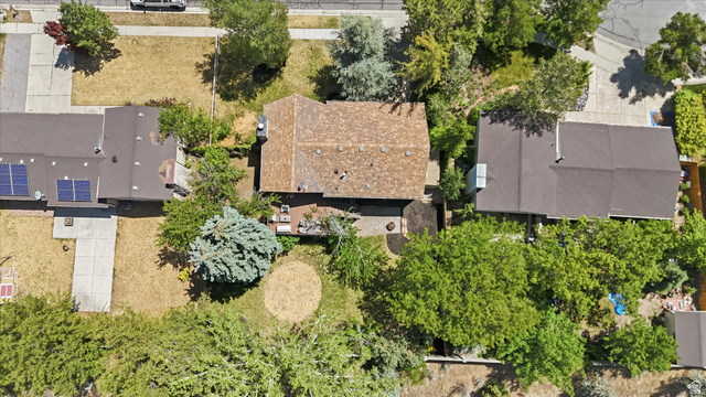 8938 Manchester Lane Sandy, UT 84093 - Photo 43 of 50 Aerial property overview featuring a shingled roof, mature trees, and concrete pathways