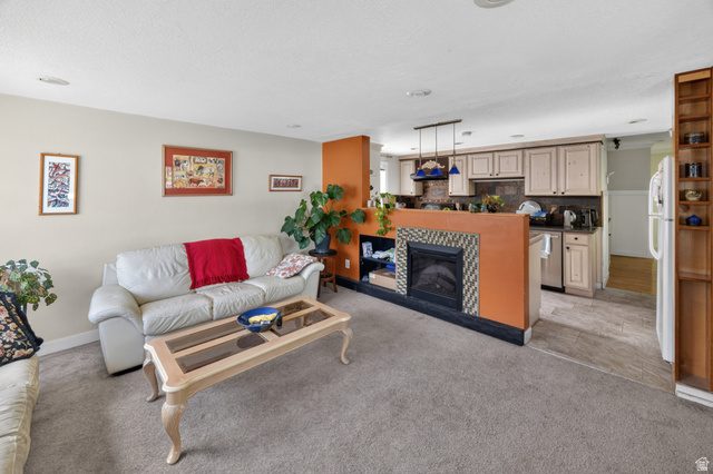 730 East 200 North Logan, UT 84321 - Photo 5 of 28 Open-concept living area with carpeted flooring and a built-in electric fireplace featuring decorative tile surround