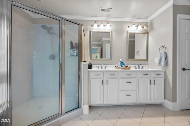 a bathroom with a double vanity sink mirror and shower