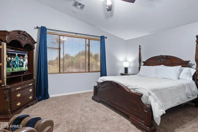 a bedroom with a bed couch and a ceiling fan