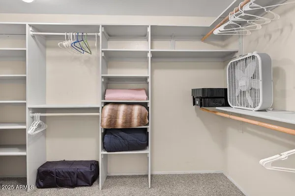 a bedroom with a bed a dresser next to a window