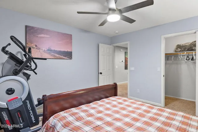 a bedroom with a bed a lamp and a large window