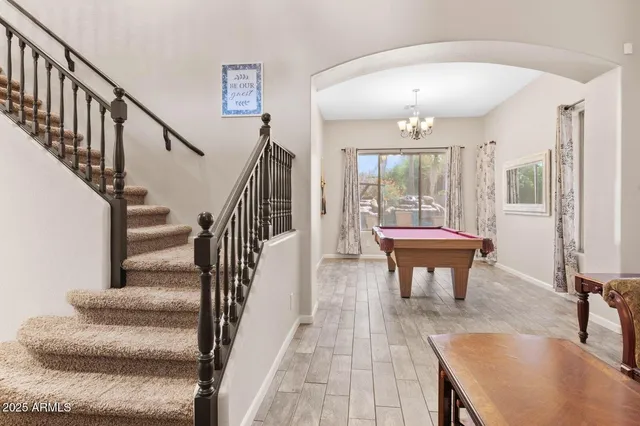 a dining room with furniture a chandelier and wooden floor