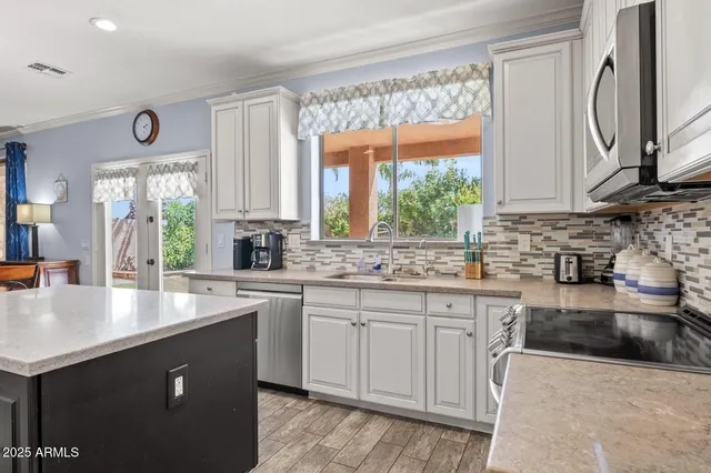 a kitchen with stainless steel appliances granite countertop a sink stove and refrigerator