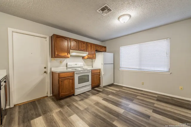 a kitchen with a stove a sink and a refrigerator