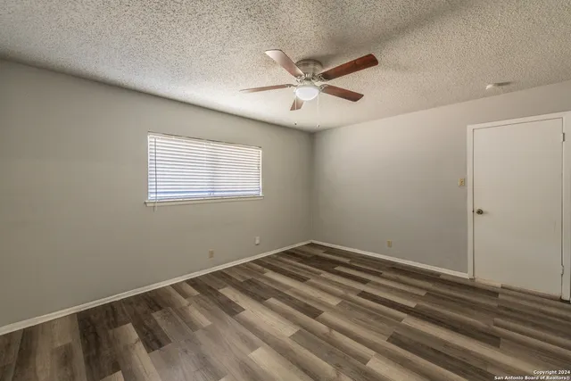 a view of a big room with wooden floor closet and windows