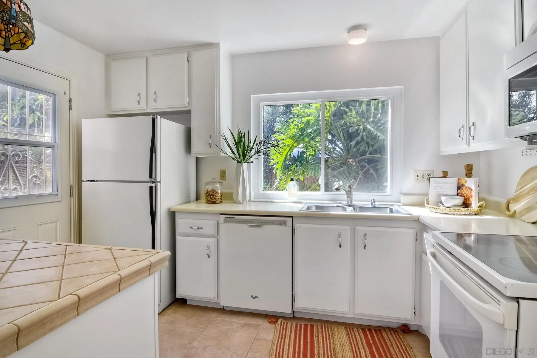 803 Caminito Azul Carlsbad, CA 92011 - Photo 12 of 41 a kitchen with white cabinets and white appliances