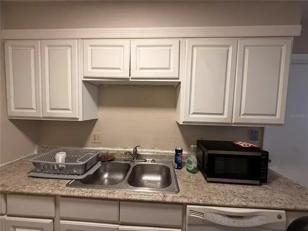 a kitchen with granite countertop white cabinets and a sink