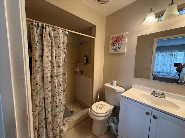 a bathroom with a sink a toilet and shower curtain
