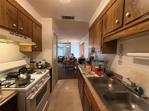 a kitchen with lots of counter top space stove and wooden floor