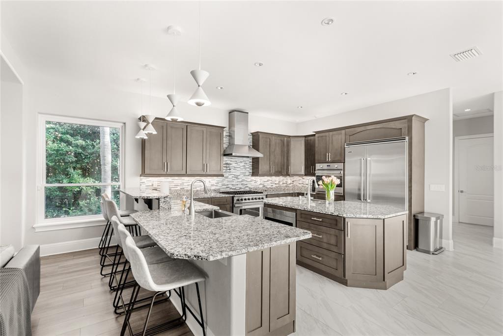 11255 Macaw Court Windermere, FL 34786 - Photo 11 of 49 a kitchen with granite countertop cabinets stainless steel appliances and dining table