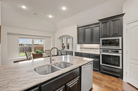 a kitchen with granite countertop a sink and appliances