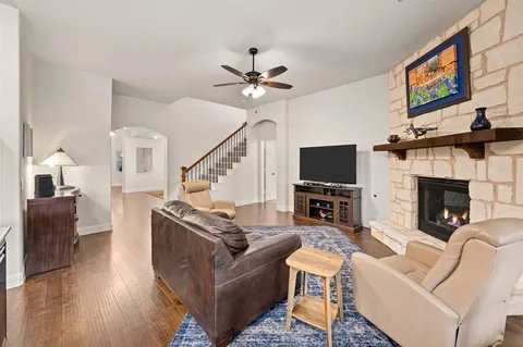 a living room with furniture a flat screen tv and a fireplace