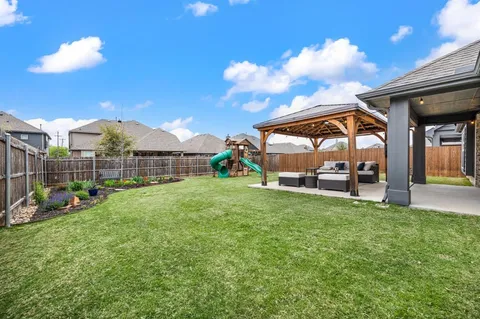 a view of a backyard with a garden and entertaining space