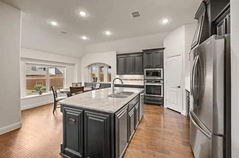 a kitchen with kitchen island a sink stove and refrigerator