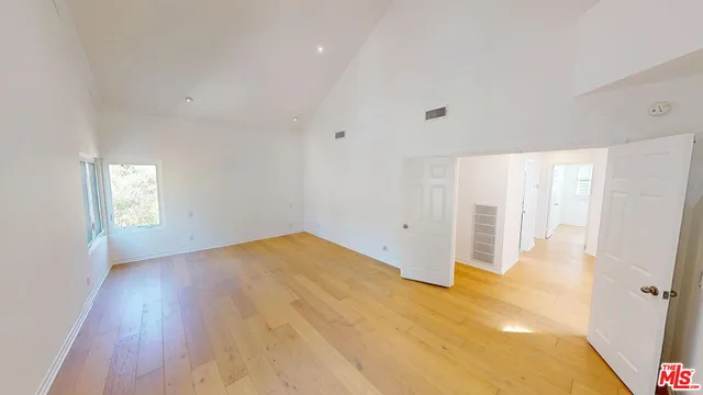 a view of empty room with wooden floor