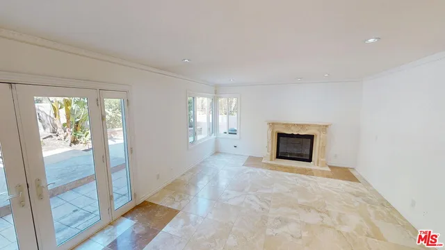 a view of an empty room with glass door and windows
