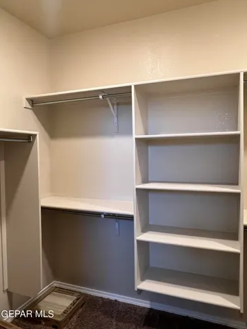 a view of walk in closet with empty racks
