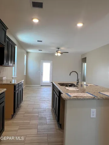 a kitchen with stainless steel appliances granite countertop a sink a stove top oven a counter space and cabinets