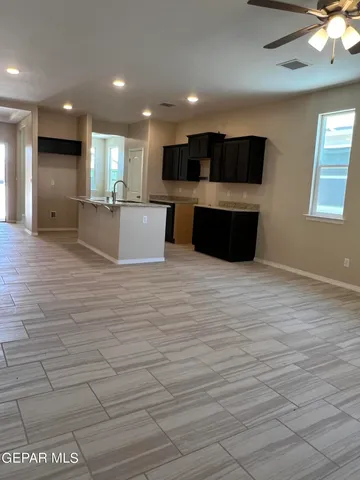 a large room with kitchen island lots of wooden furniture