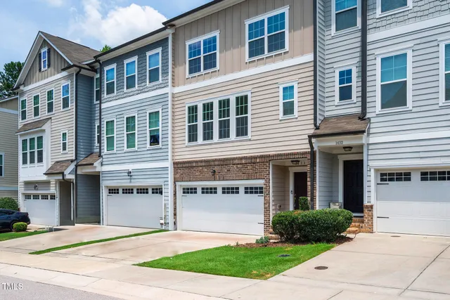 a front view of a house with yard and parking
