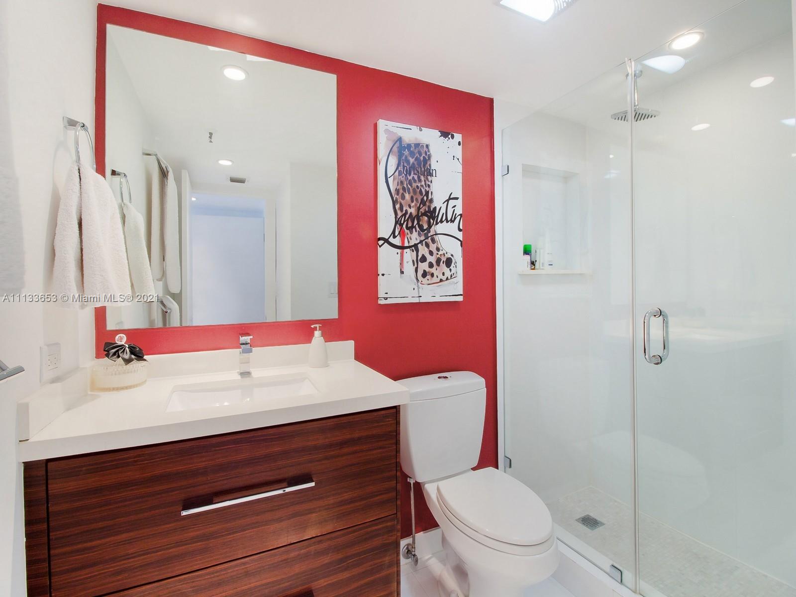 520 Brickell Key Drive, Unit A1815 Miami, FL 33131 - Photo 15 of 34 a bathroom with a sink a toilet a shower and a mirror