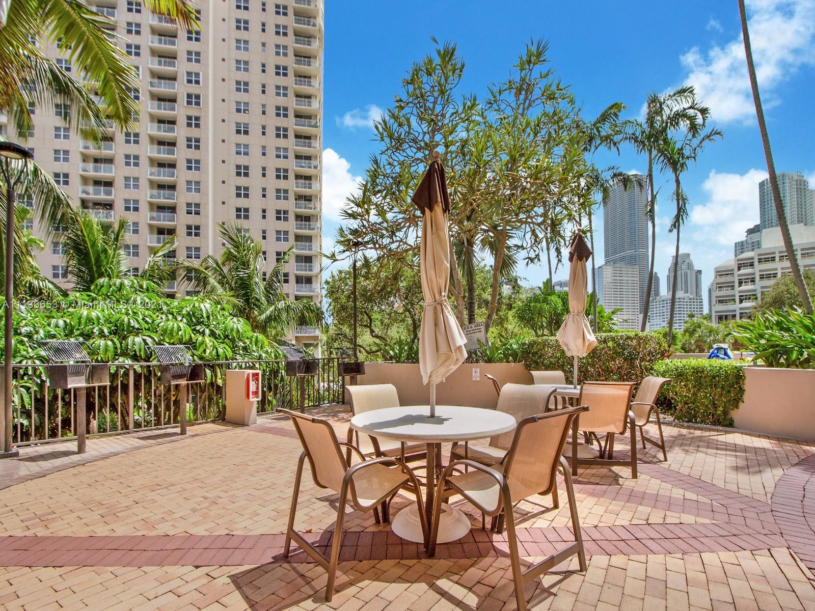 520 Brickell Key Drive, Unit A1815 Miami, FL 33131 - Photo 19 of 34 a view of a patio with table and chairs and potted plants