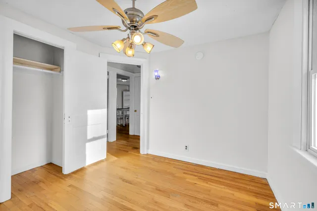 a view of a livingroom with wooden floor and a ceiling fan