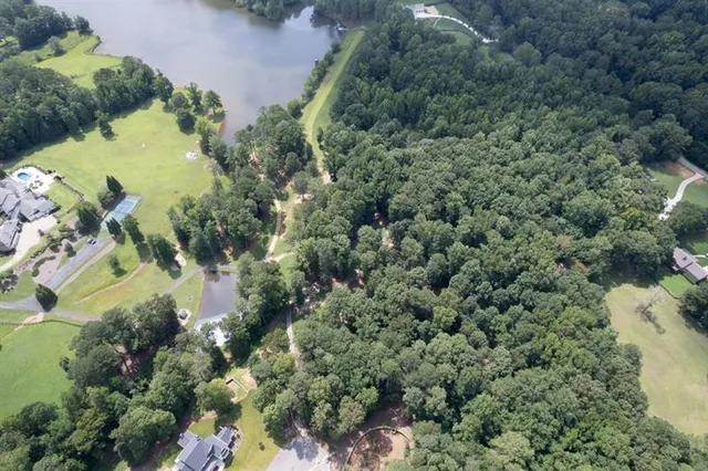 an aerial view of residential house with outdoor space and trees all around