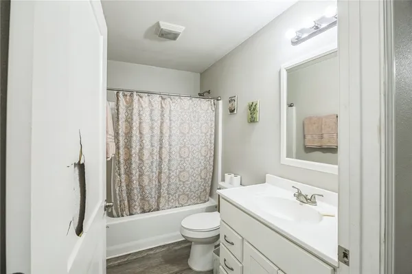 a bathroom with a sink a toilet and shower curtain